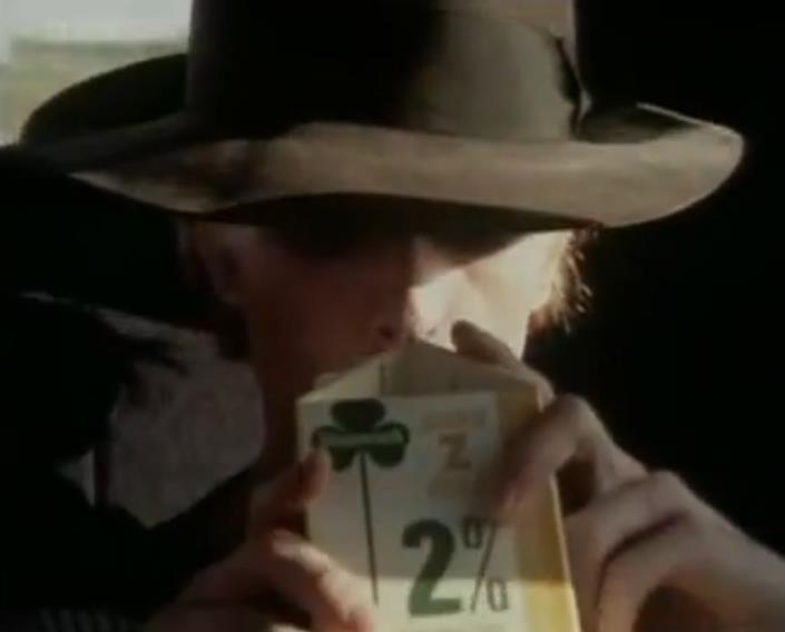 David Bowie sosteniendo un cartón de leche, fotograma de la película The Man Who Fell to Earth (1976).